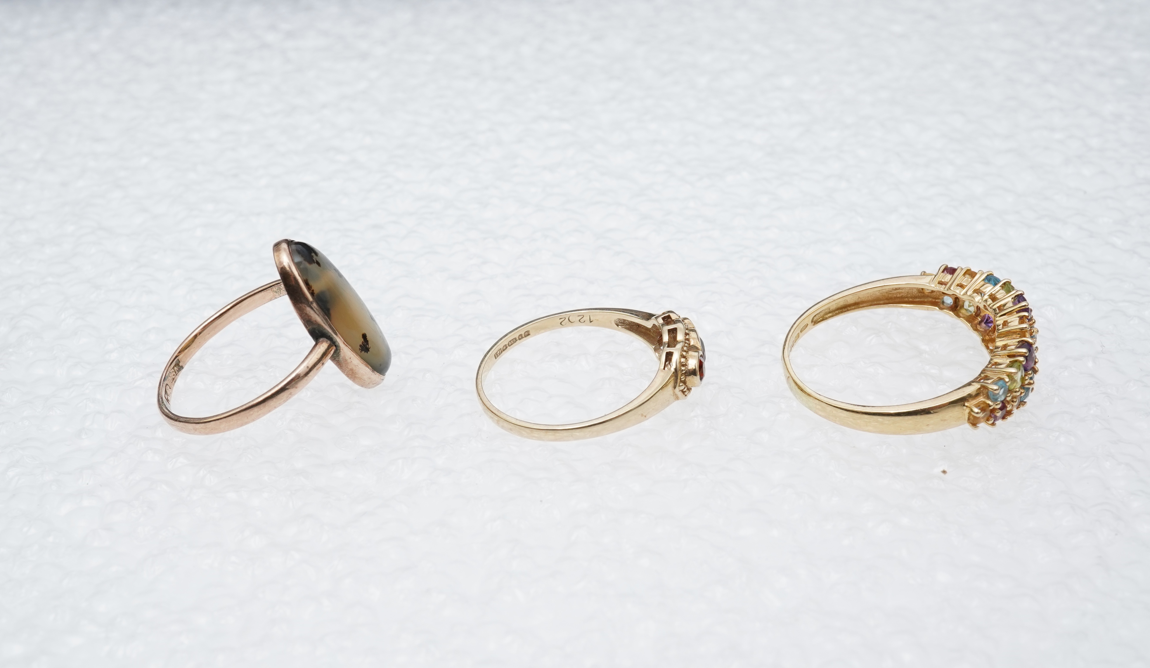A modern 18ct gold and multi gem set cluster ring, size P, together with two 9ct rings including moss agate and a pair of 9ct gold and seed pearl set cabochon garnet ear studs.